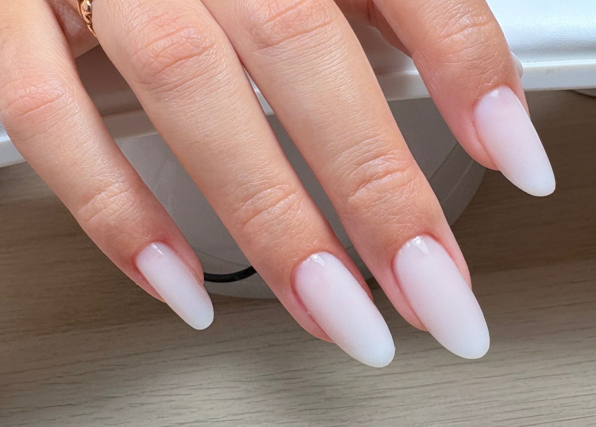 Unhas brancas e elegantes em formato amêndoa no salão Bruna Duarte, Braga, Braga, PT.