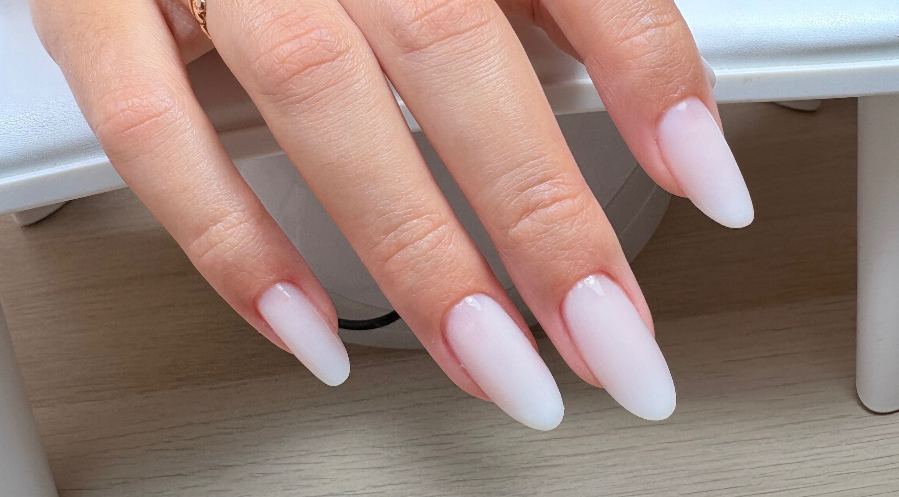 Unhas brancas e elegantes em formato amêndoa no salão Bruna Duarte, Braga, Braga, PT.