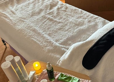 Relax & Glow therapy room in Swindon, England, GB, showcasing a massage table and skincare products.