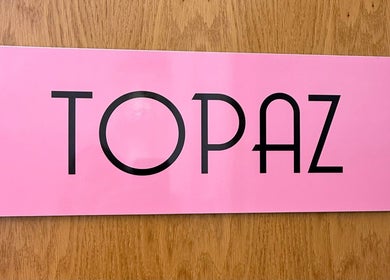 Topaz area at Relax & Glow, Swindon, England, GB features a pink backdrop with bold black text.
