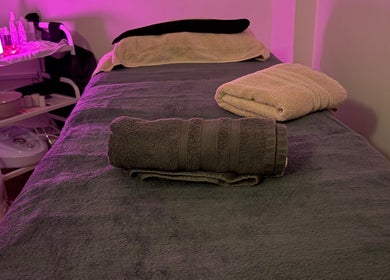 Relax & Glow treatment room with massage bed in Swindon, England, GB. Towels and relaxing ambiance included.