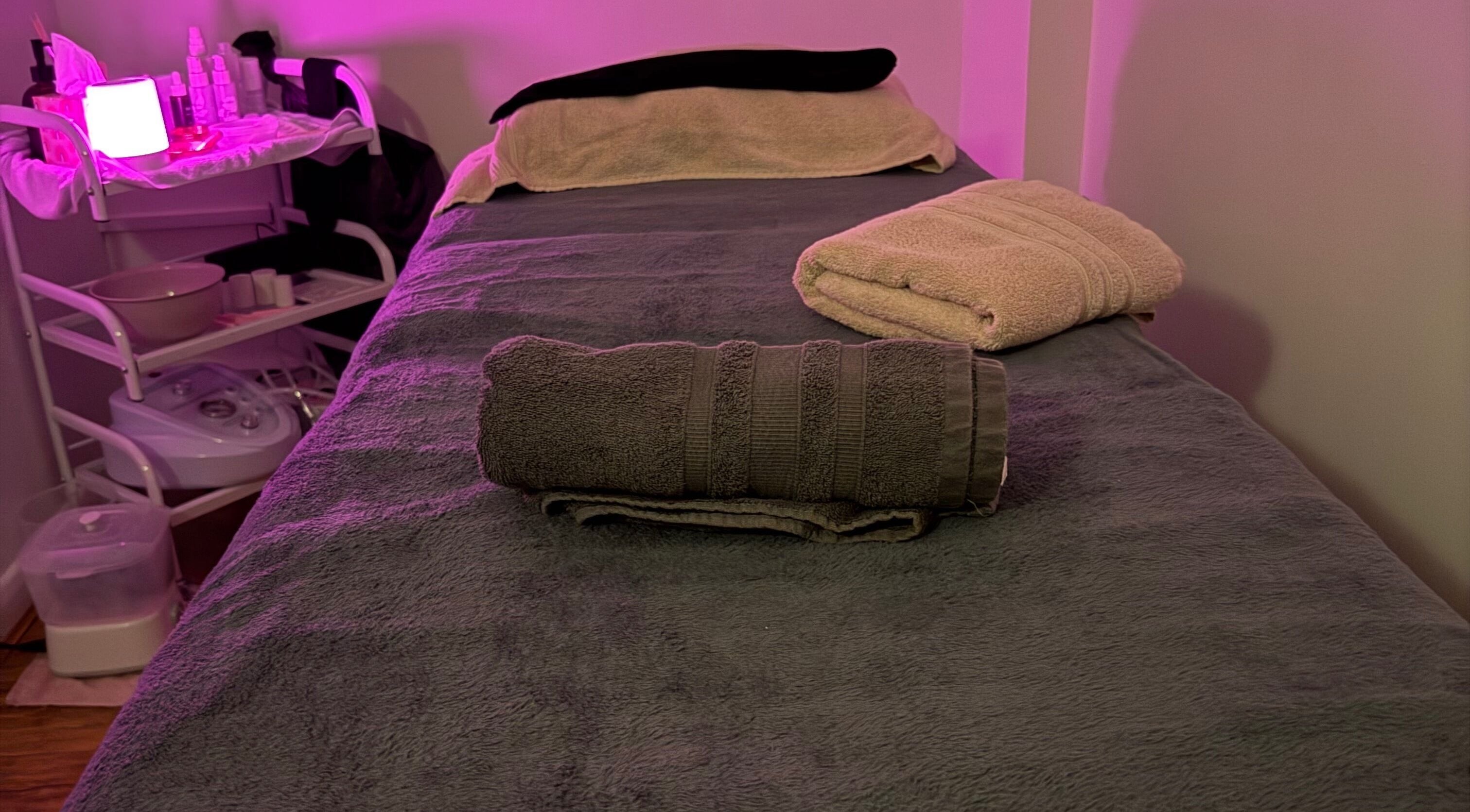 Cozy massage table at Relax & Glow, Swindon, England, GB, with soft lighting and fresh towels.
