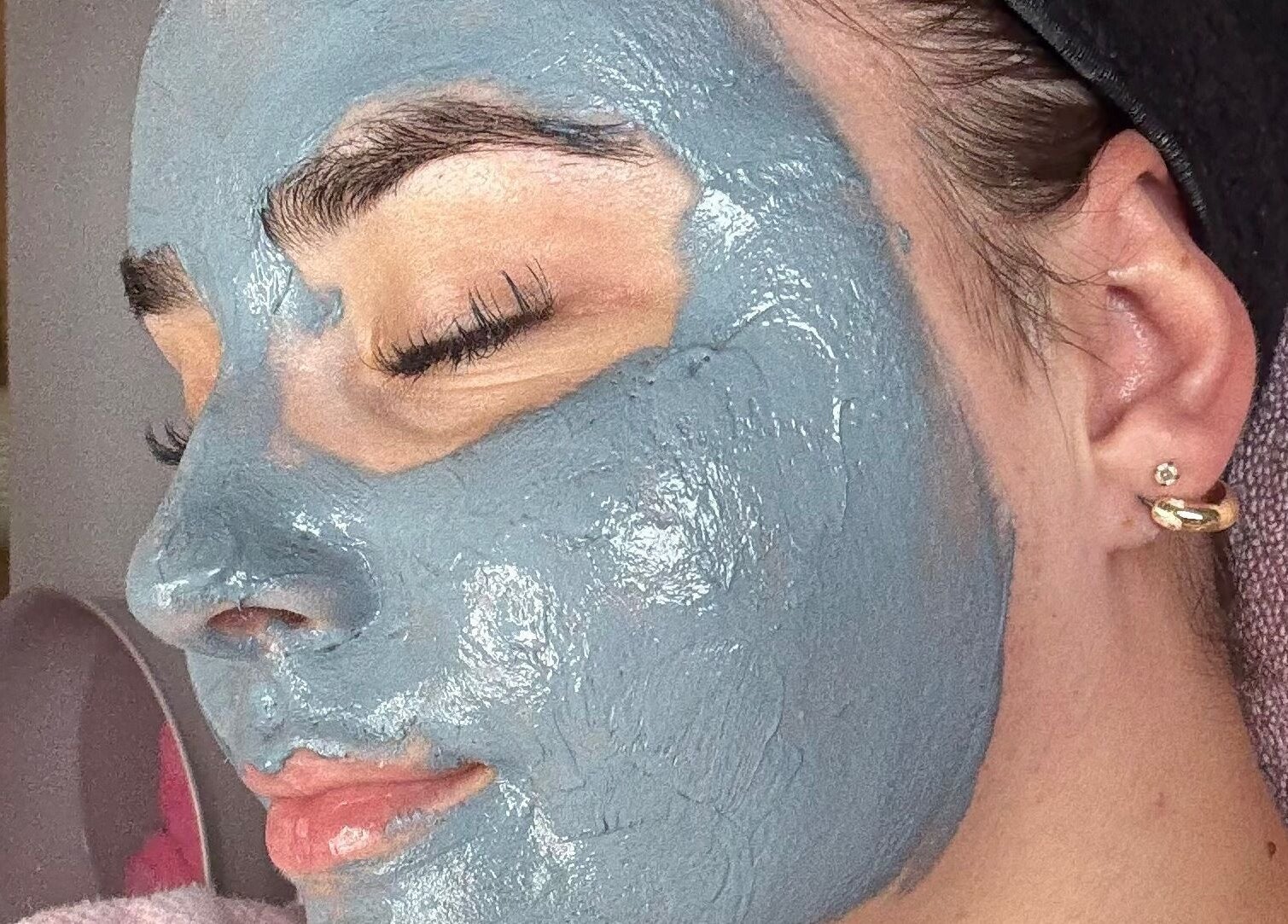 A woman relaxing with a blue face mask at Relax & Glow, Swindon, England, GB.