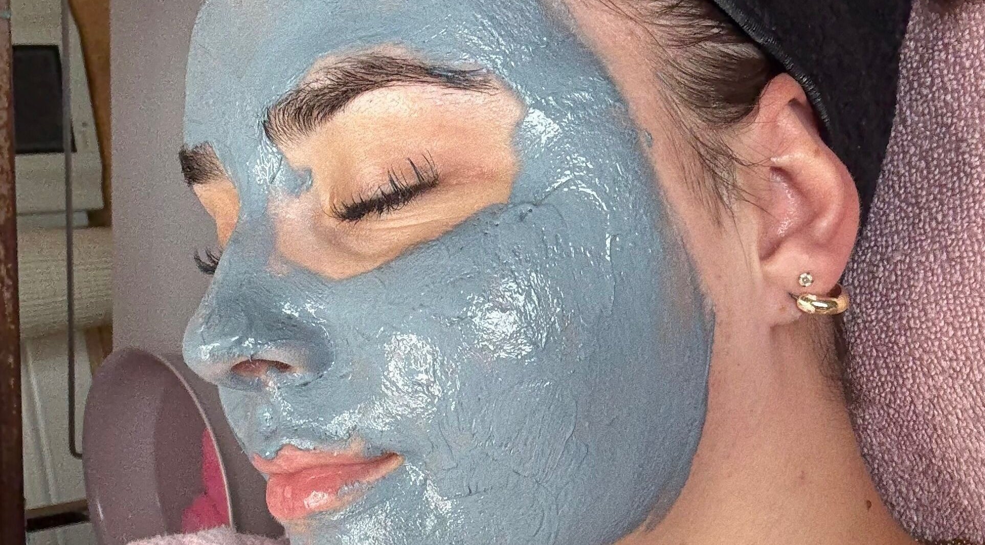 A woman relaxing with a blue face mask at Relax & Glow, Swindon, England, GB.