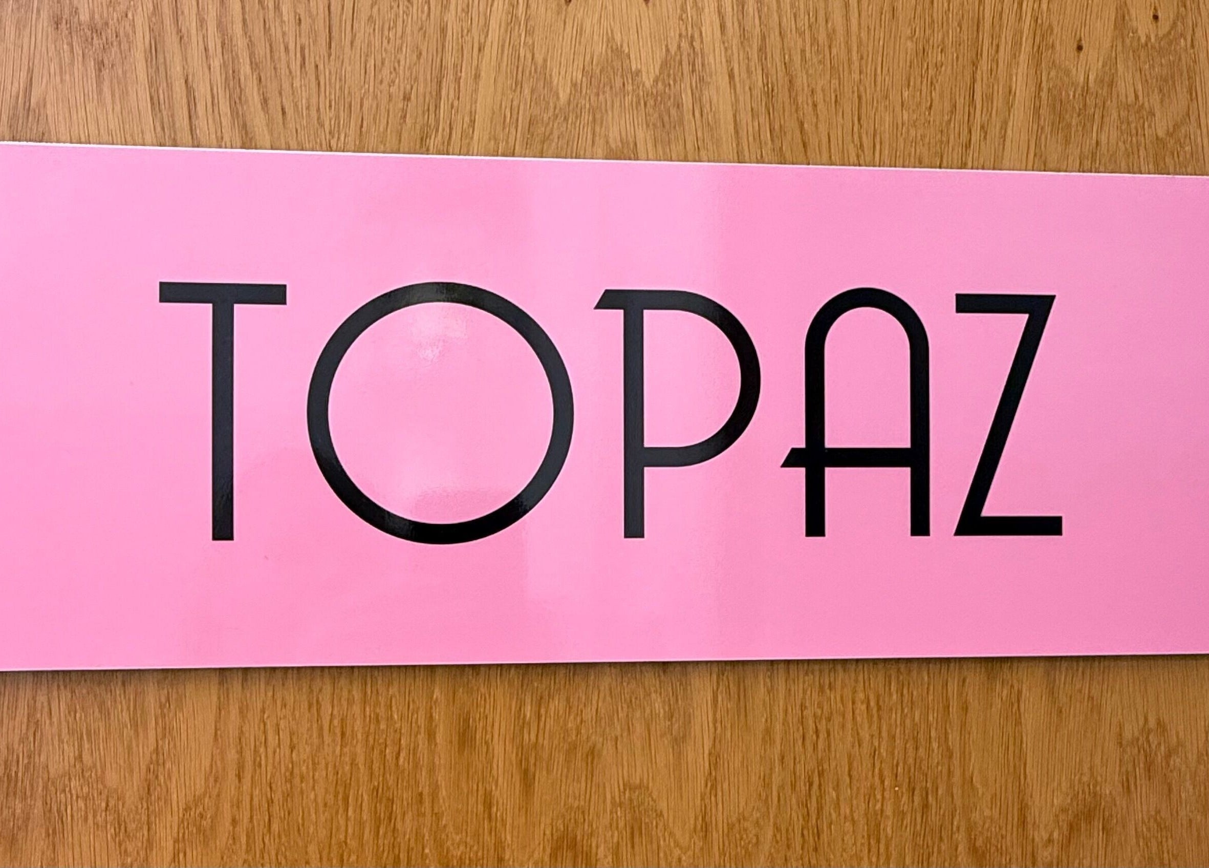 Topaz room sign at Relax & Glow, Swindon, England, GB. Bright pink with bold black lettering.