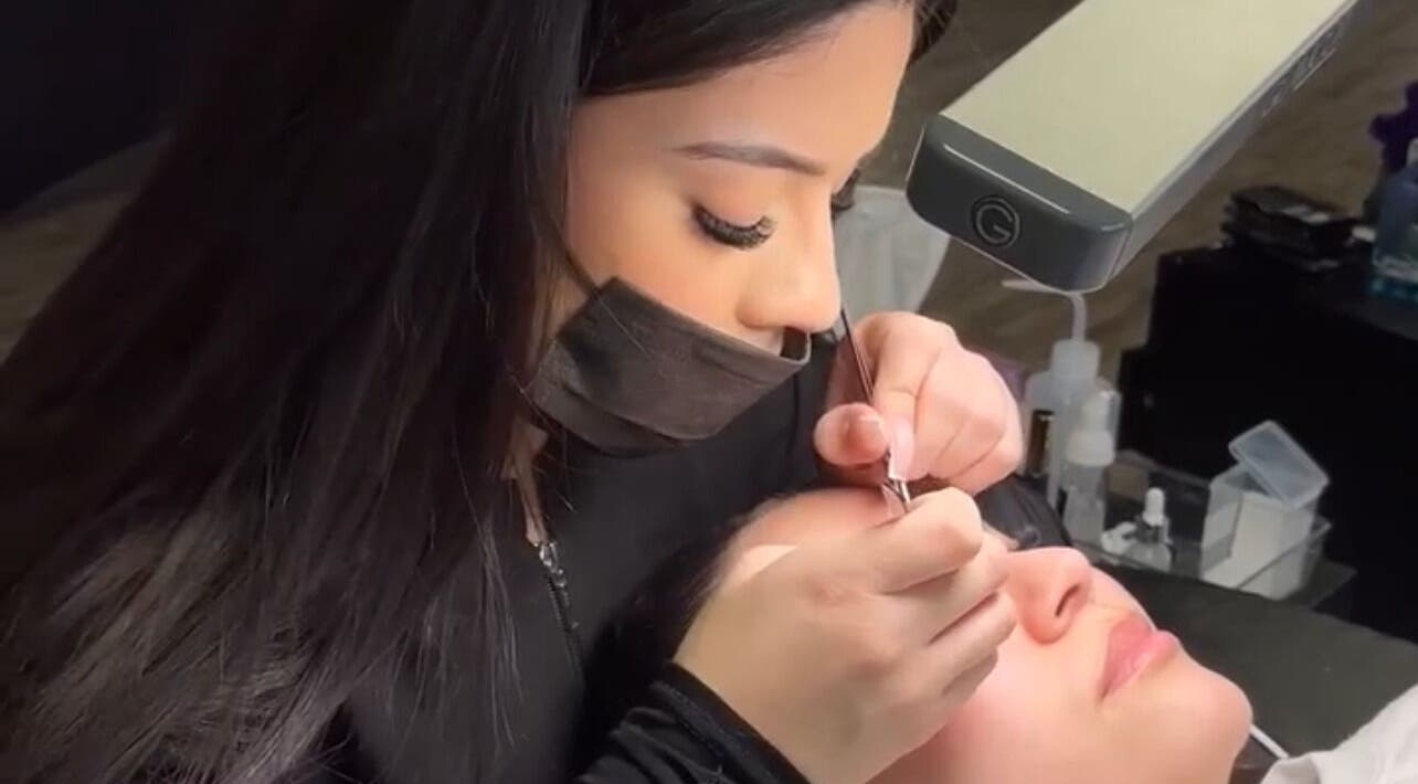 Technicienne appliquant des extensions de cils chez Lashes By Navarrita à Montréal, Québec, CA.
