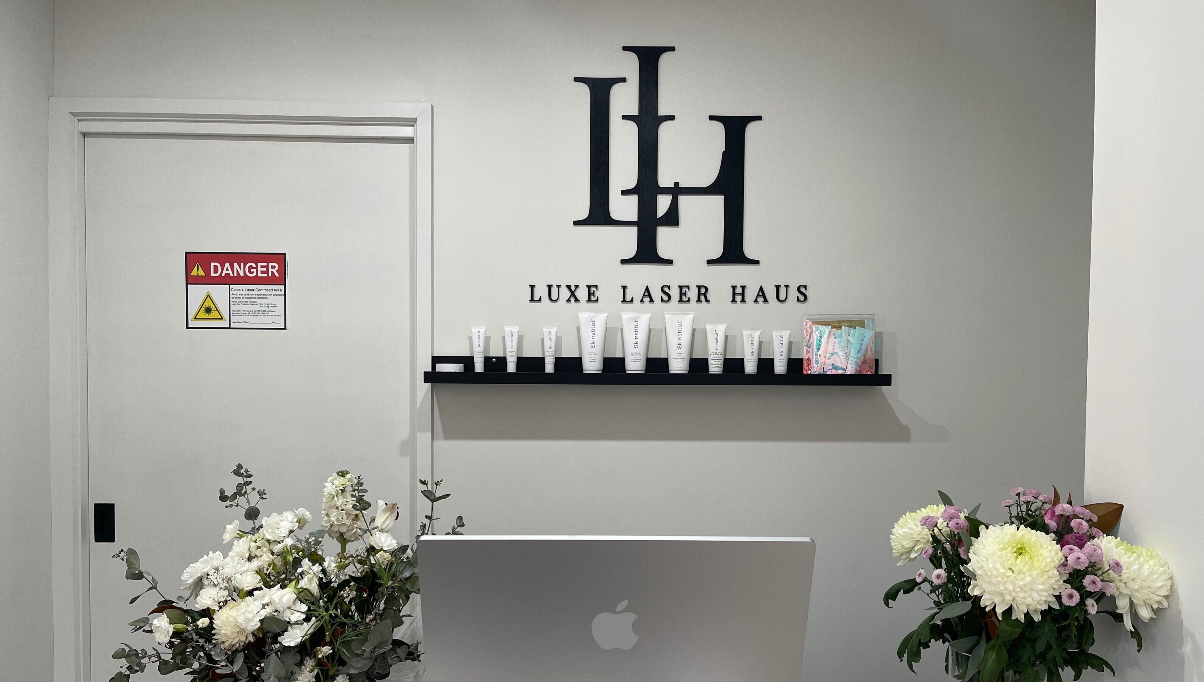 Luxe Laser Haus entrance with logo shelf and flowers in Carnegie, Victoria, AU.
