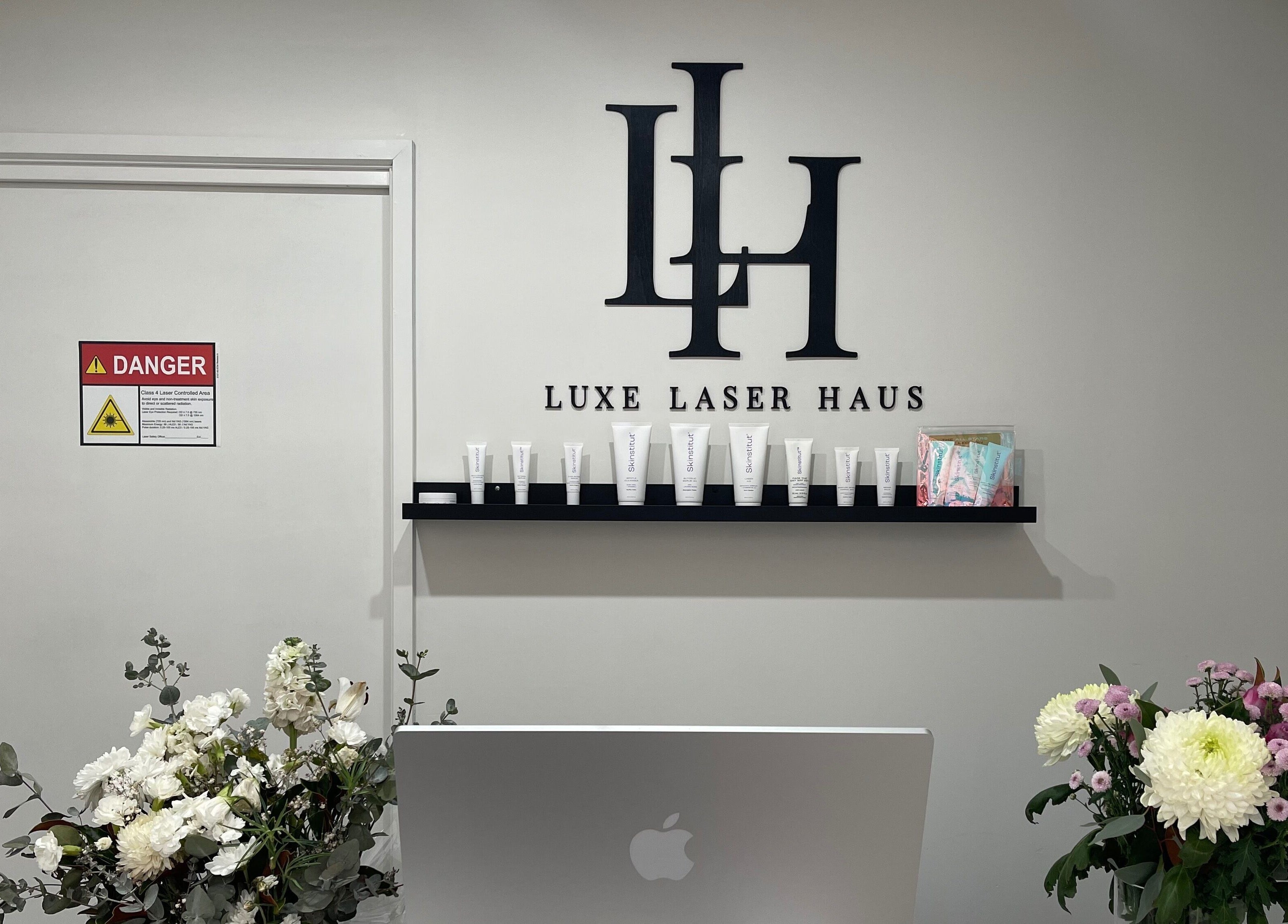 Luxe Laser Haus entrance with logo shelf and flowers in Carnegie, Victoria, AU.