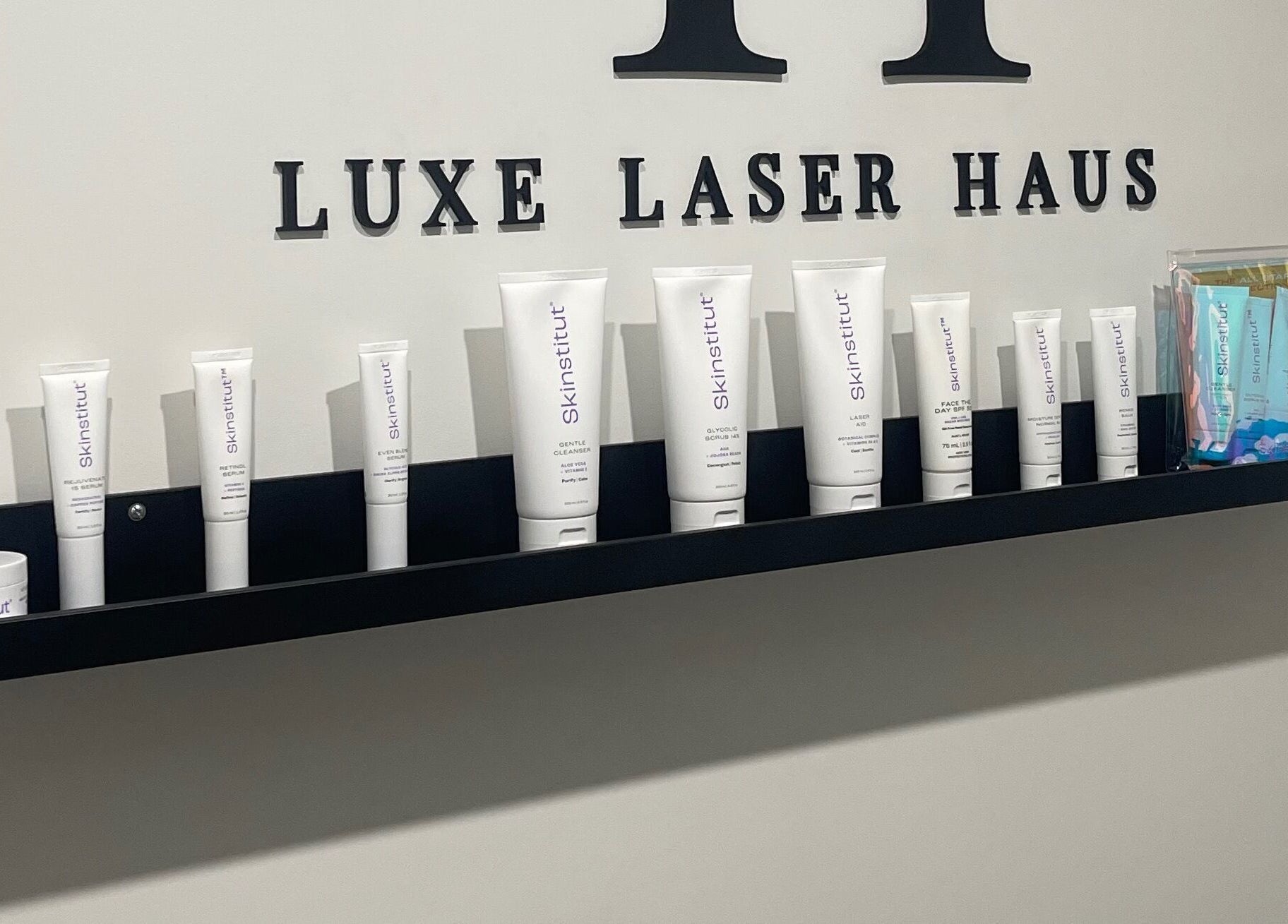 Luxe Laser Haus in Carnegie, Victoria, AU displays premium skincare products on a sleek black shelf.