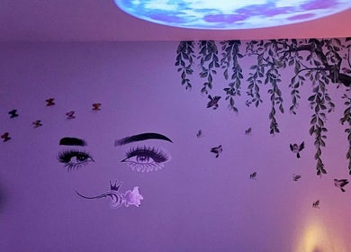 Artistic wall mural at Glowing Beauty in Christchurch, Canterbury, NZ, featuring eyes and nature elements.