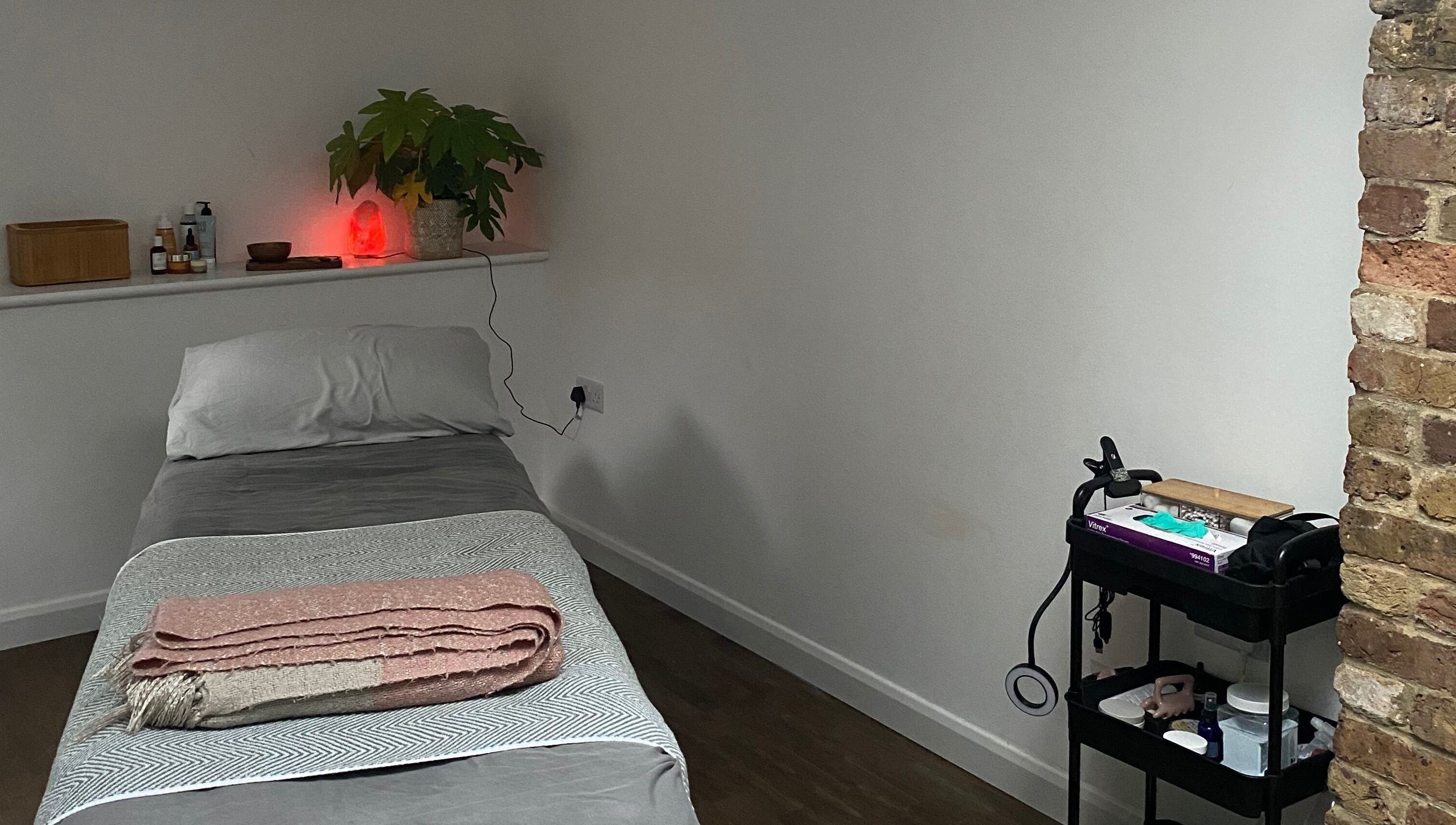 Cozy treatment room at Retreat Yourself Studio, Braintree, England, GB with massage table and soft lighting.