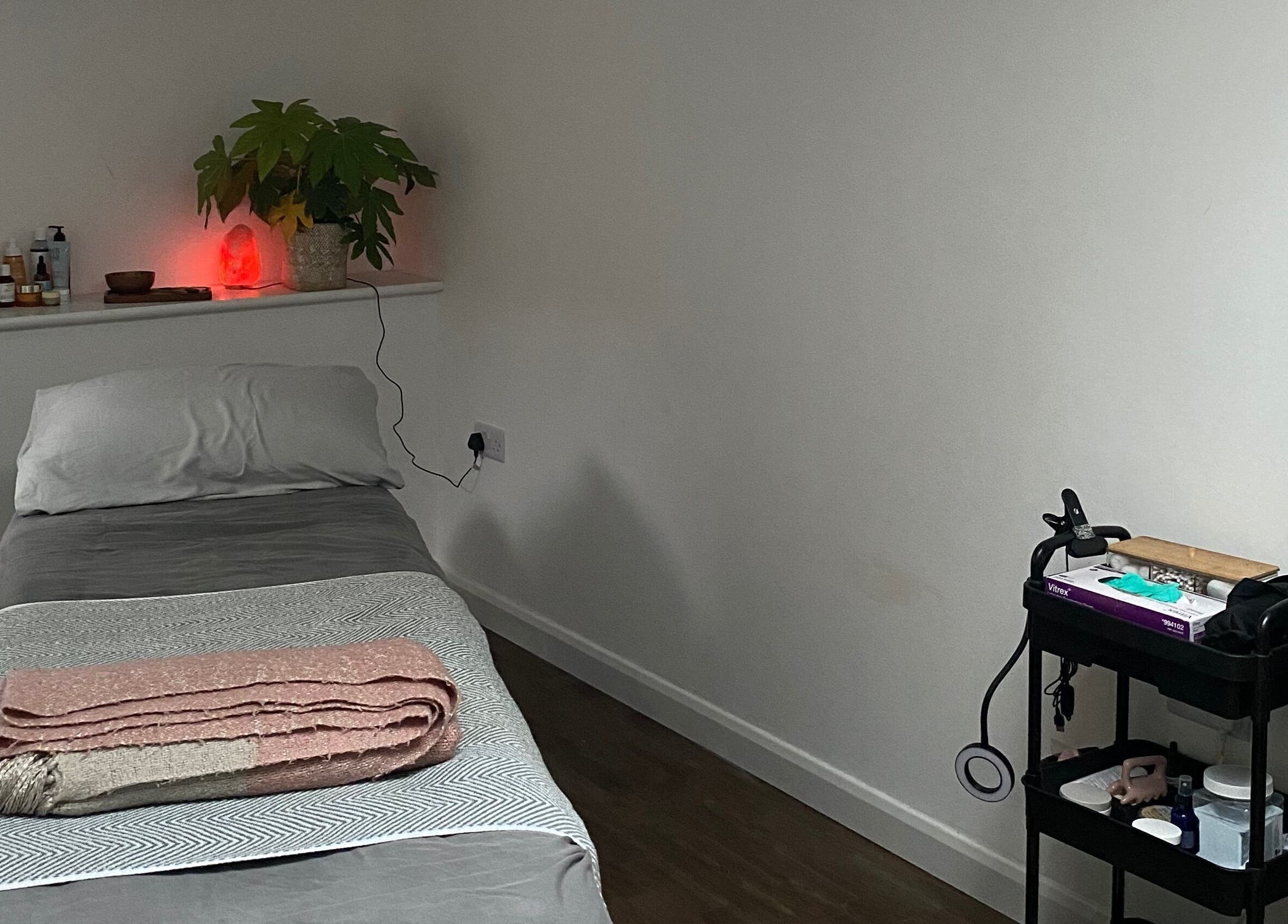Cozy treatment room at Retreat Yourself Studio, Braintree, England, GB with massage table and soft lighting.