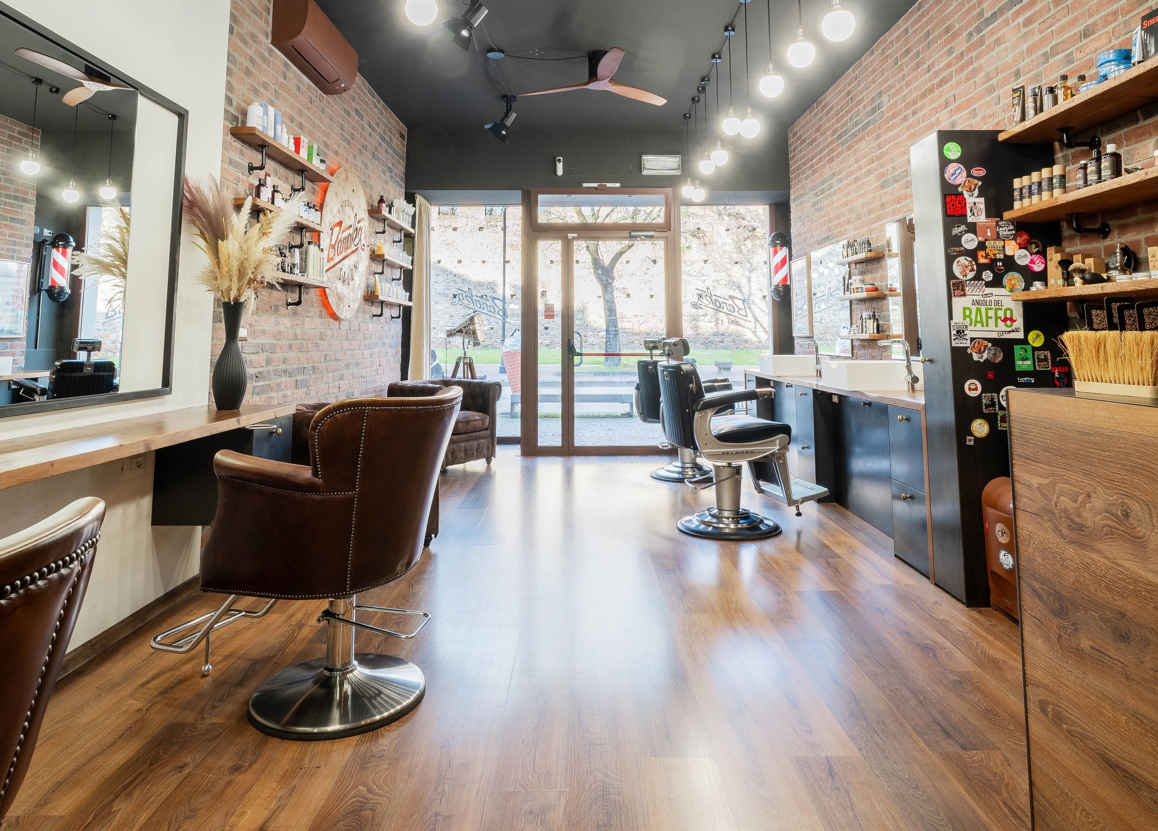 Interno raffinato di Baraka Salon, Este, Veneto, IT, con arredi moderni e pareti in mattoni.