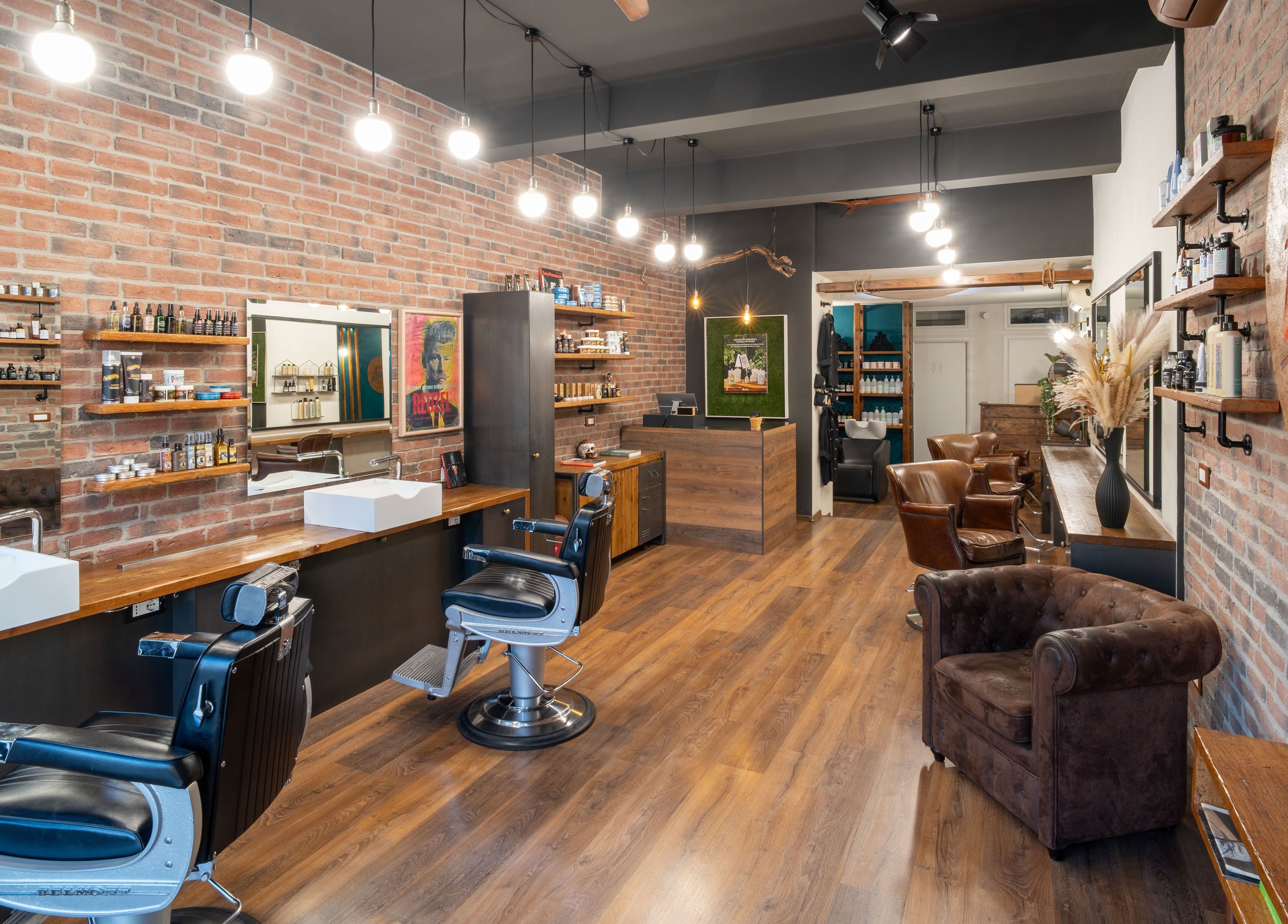 Interni eleganti di Baraka Salon a Este, Veneto, IT con pareti di mattoni e sedie in pelle.