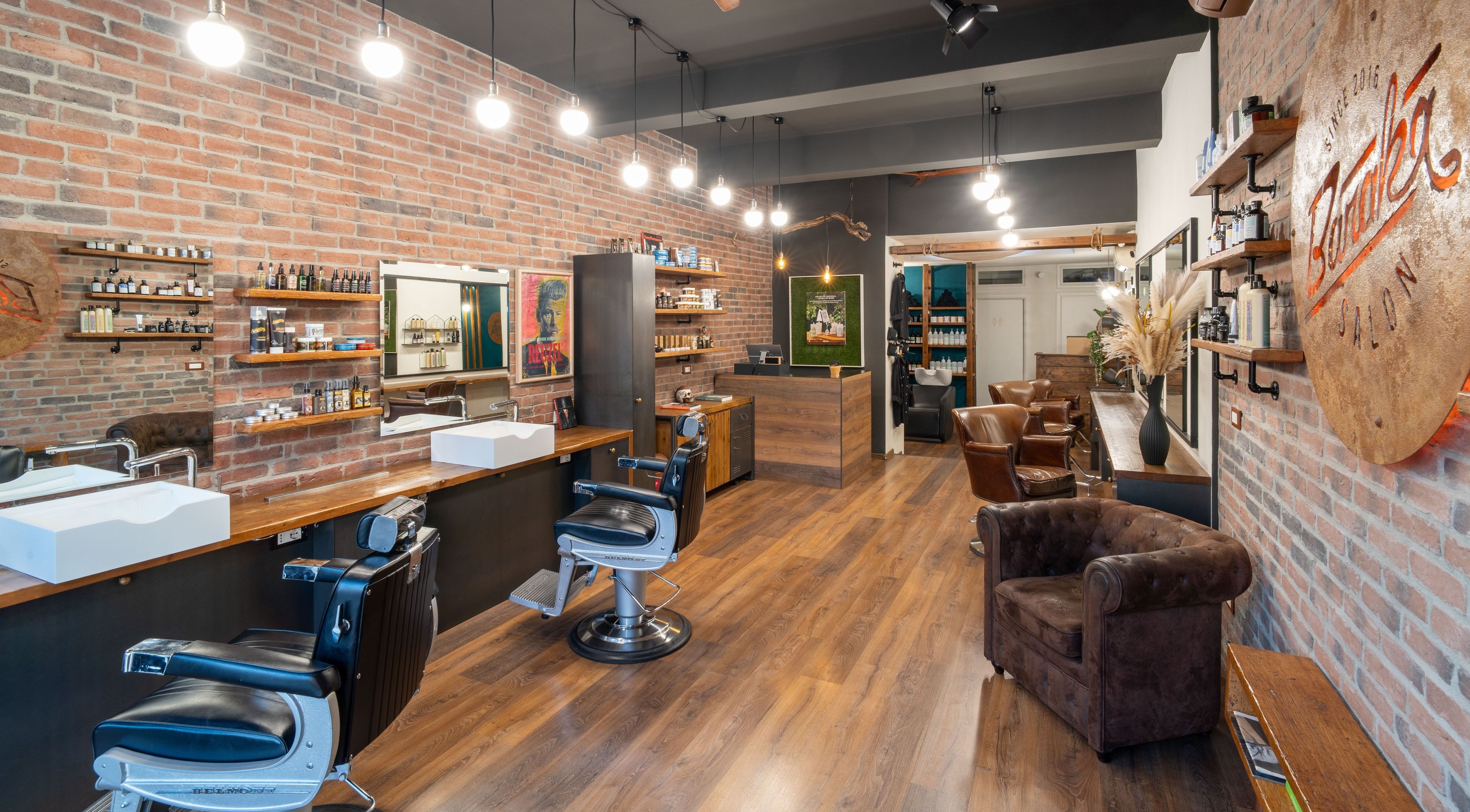 Interni eleganti di Baraka Salon a Este, Veneto, IT con pareti di mattoni e sedie in pelle.