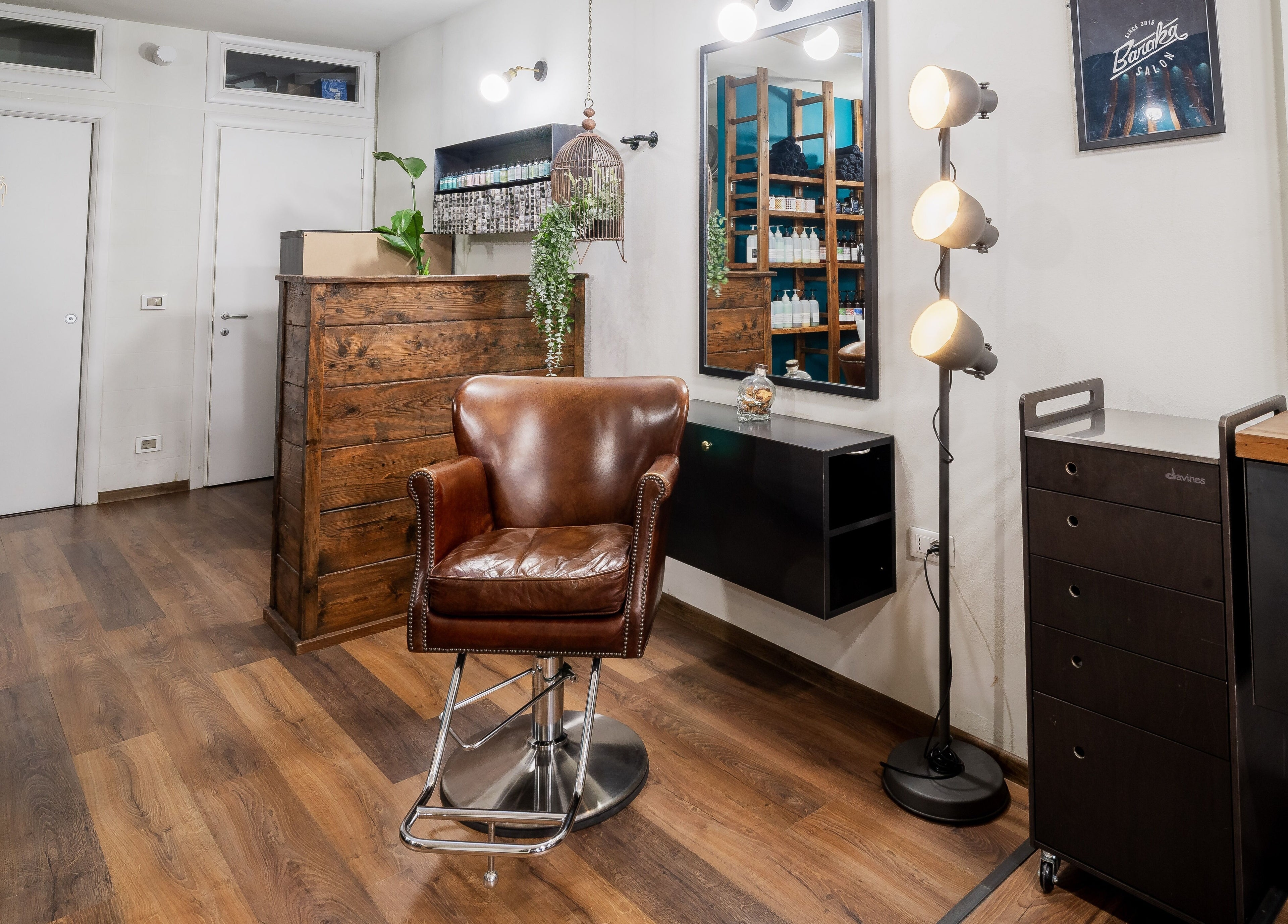 Interno elegante di Baraka Salon a Este, Veneto, IT con sedie in pelle e legno scuro.