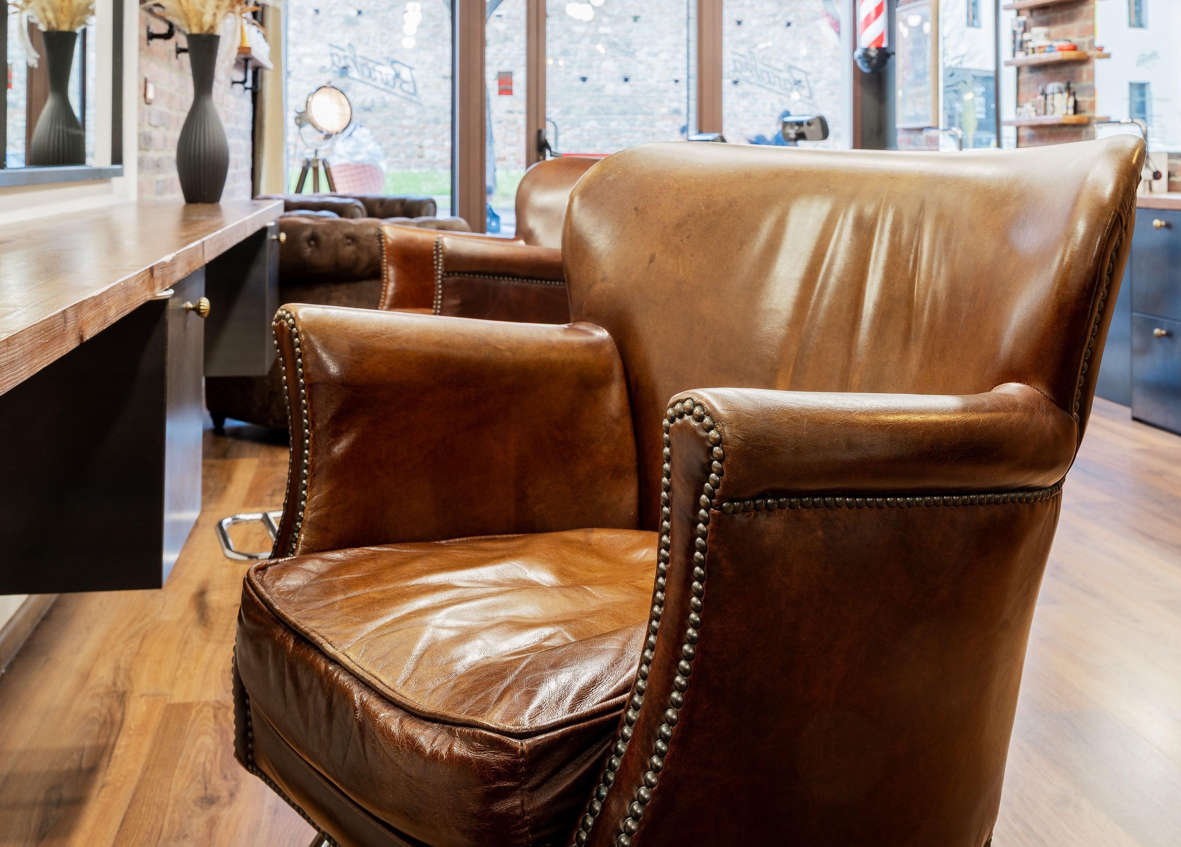 Poltrona in pelle vintage al Baraka Salon, Este, Veneto, IT. Atmosfera raffinata e accogliente.