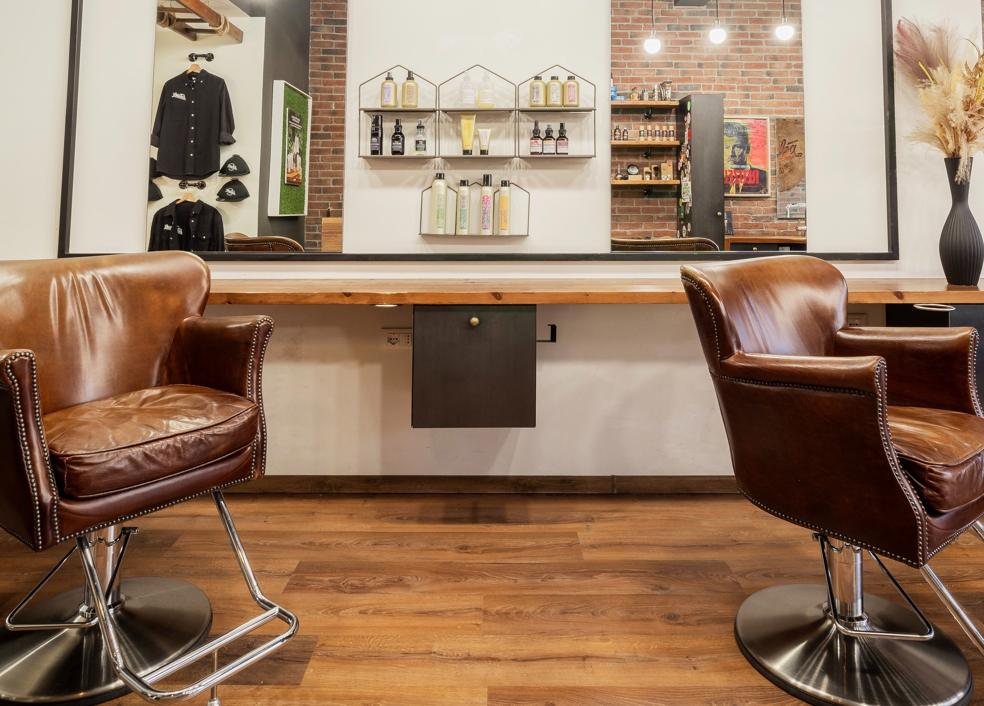 Sedie in pelle marrone presso Baraka Salon a Este, Veneto, IT, con arredi eleganti e prodotti di bellezza esposti.