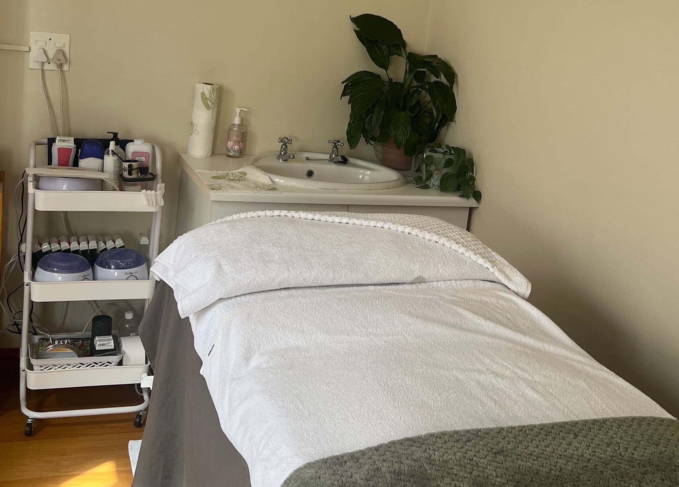Relaxing treatment room at Jessie Beauty, Cape Town, Western Cape, ZA. Cozy bed and spa essentials create a serene vibe.
