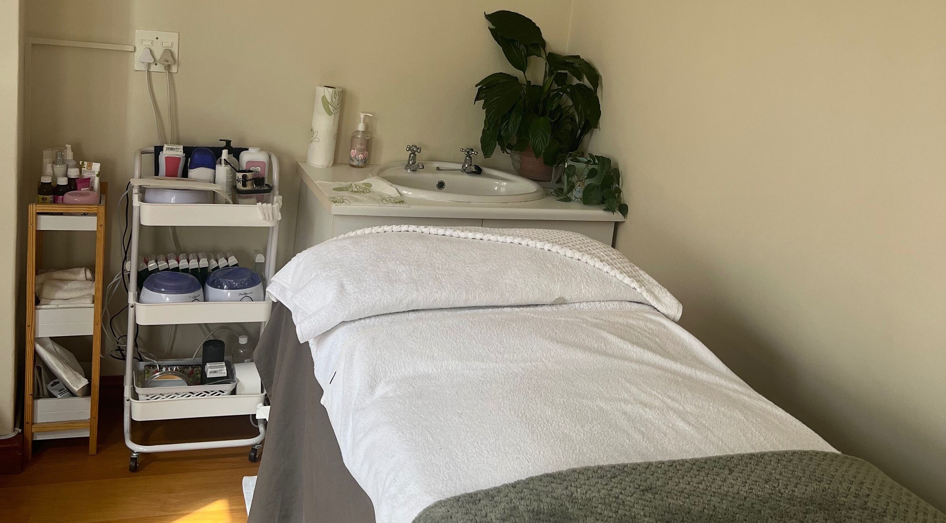 Relaxing treatment room at Jessie Beauty, Cape Town, Western Cape, ZA. Cozy bed and spa essentials create a serene vibe.