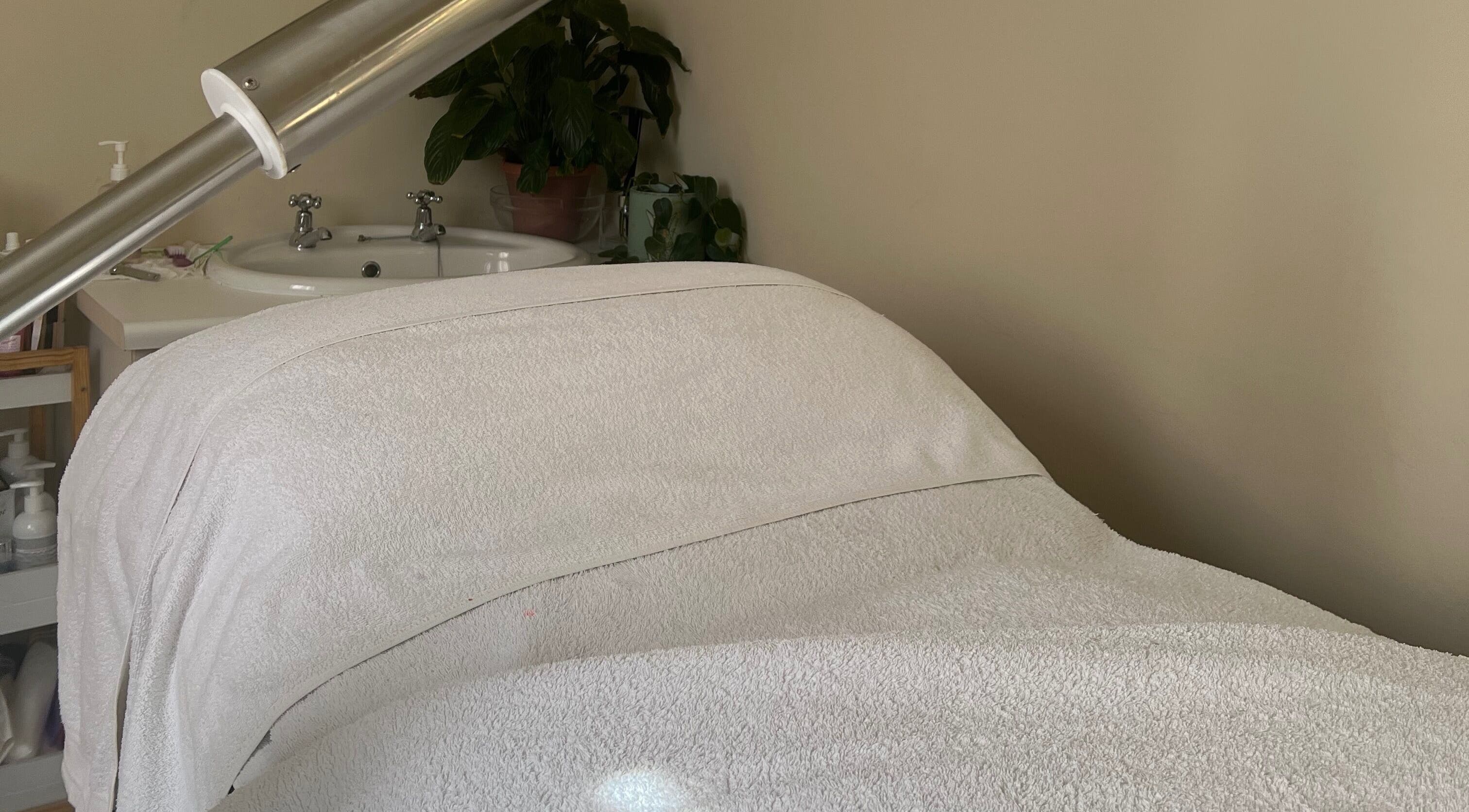 Calming spa treatment room at Jessie Beauty, Cape Town, Western Cape, ZA with massage bed and sink.