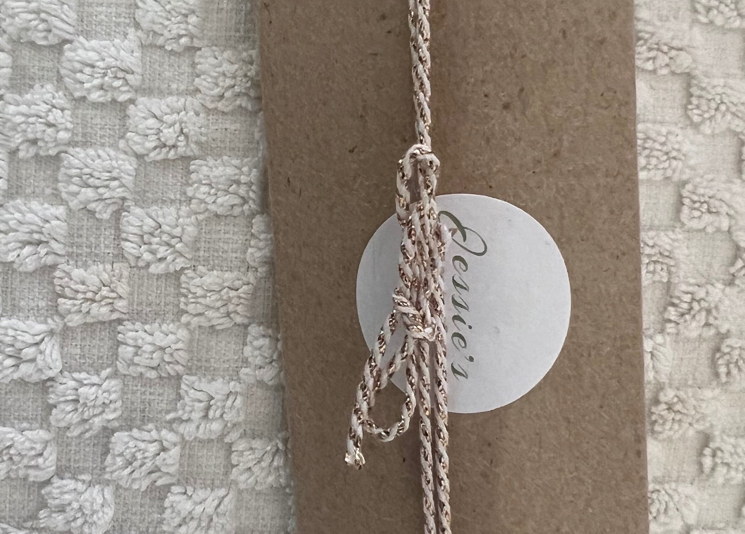 Elegant artisan package from Jessie Beauty in Cape Town, Western Cape, ZA on textured fabric.