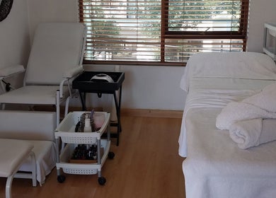Relaxing beauty treatment room at TWO'S COMPANY Hair & Beauty, Sandton, Gauteng, ZA with spa bed and towels.