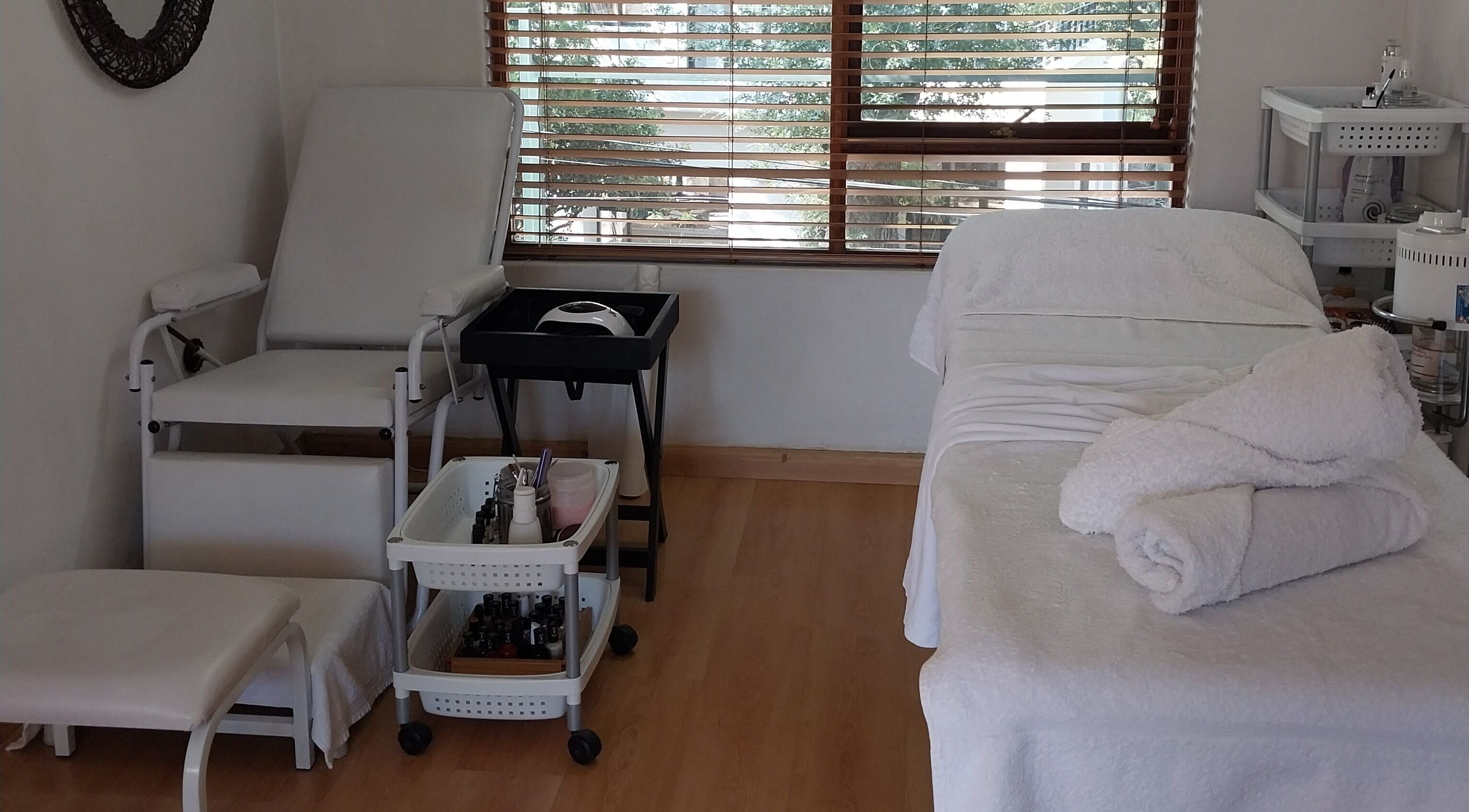 Relaxing beauty treatment room at TWO'S COMPANY Hair & Beauty, Sandton, Gauteng, ZA with spa bed and towels.