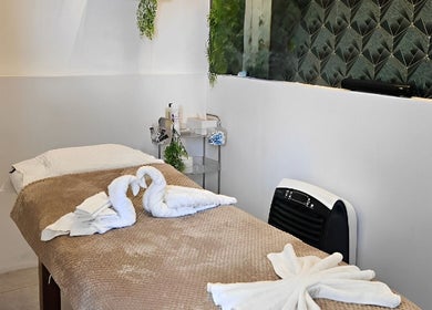 Relaxing Life Lux Salon spa room in Centurion, Gauteng, ZA, with towel art swans on a bed.