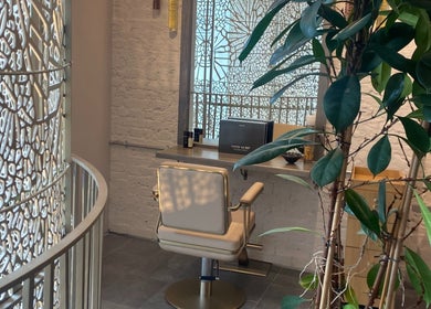 Elegant styling chair at VITA Glow Hair Salon & Head Spa, London, England, GB with modern decor and greenery.