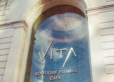 Front facade of VITA Glow Hair Salon & Head Spa, London, England, GB with elegant arch and glass design.