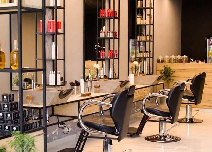 Stylish salon at Yousef Afandi-Shiekh Zayed, Giza Governorate, EG with sleek chairs and product shelves.