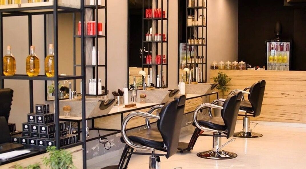 Stylish salon at Yousef Afandi-Shiekh Zayed, Giza Governorate, EG with sleek chairs and product shelves.