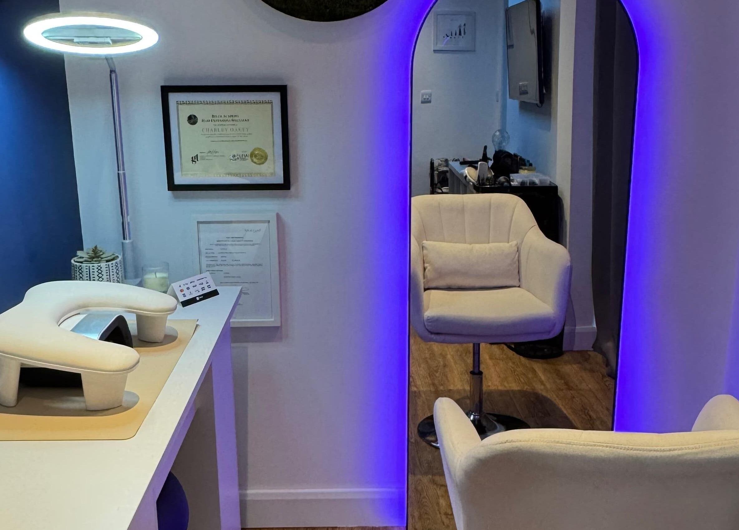 Modern salon interior at Charlotte Hannah Hair and Beauty, Somersham, England, GB with chic chair and ambient lighting.