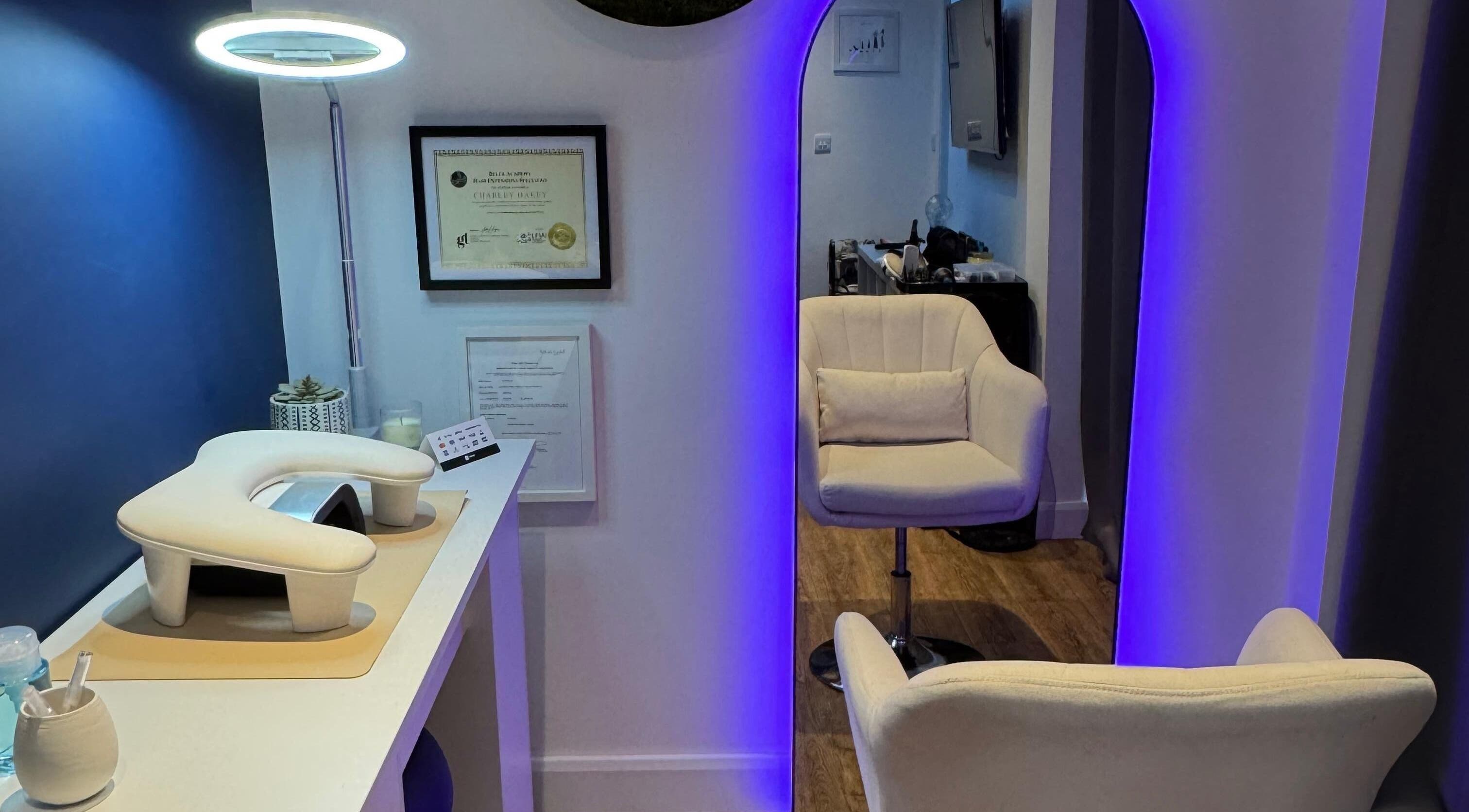 Modern salon interior at Charlotte Hannah Hair and Beauty, Somersham, England, GB with chic chair and ambient lighting.