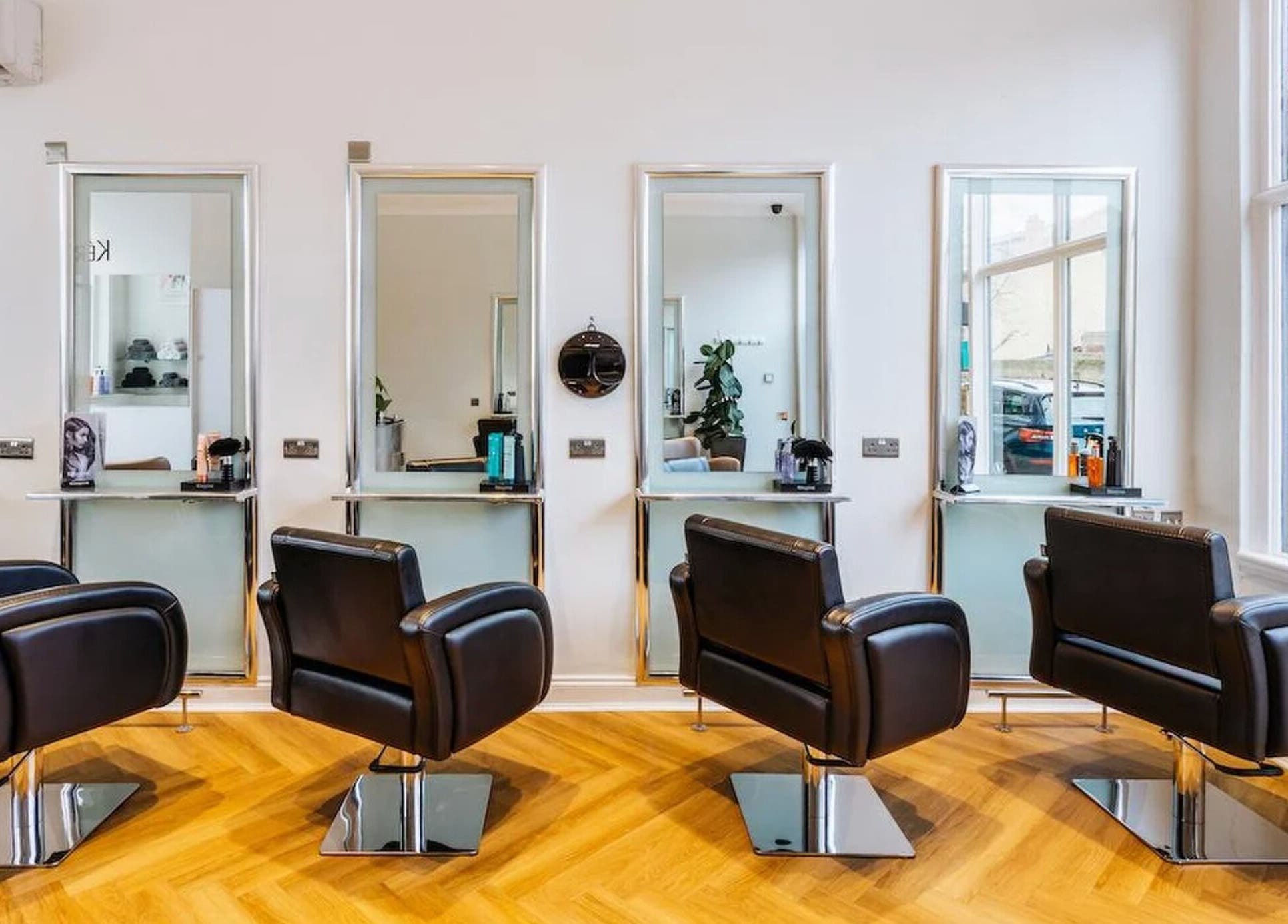Elegant interior of Making Waves Salon, London, England, GB, showcasing four sleek styling chairs and mirrors.