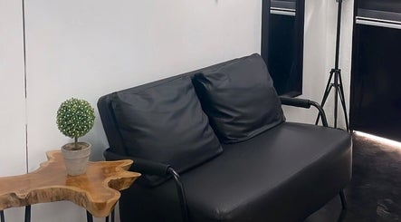 Cozy black sofa and wooden table at StudioGunteng, Cheras, Wilayah Persekutuan Kuala Lumpur, MY.