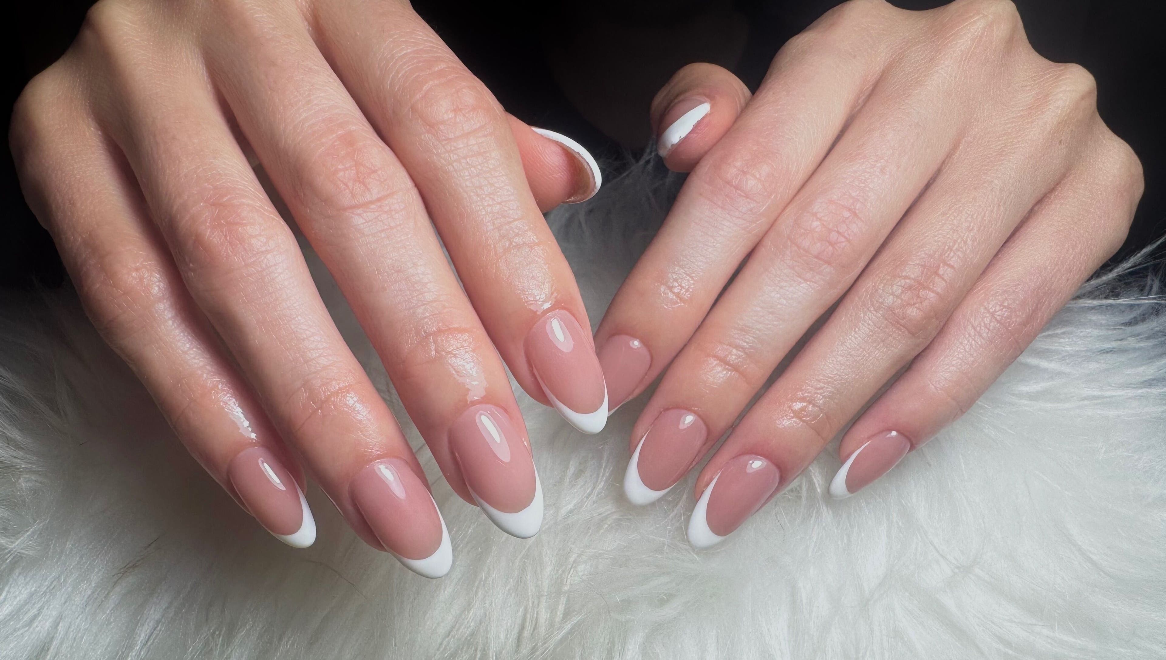 Manicura francesa elegante en Dja Nails, Heredia, Heredia, CR sobre tela blanca.