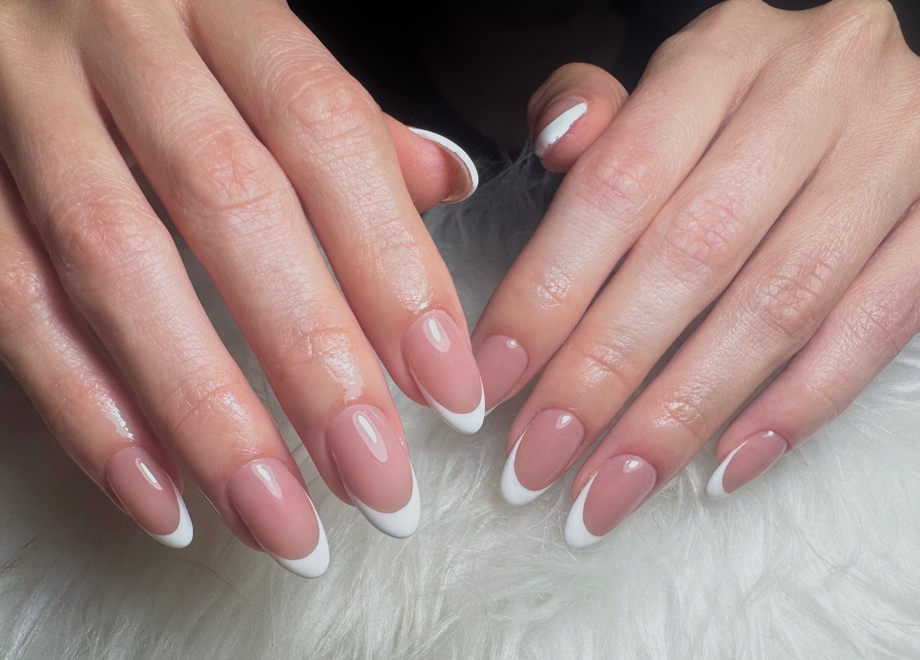 Manicura francesa elegante en Dja Nails, Heredia, Heredia, CR sobre tela blanca.