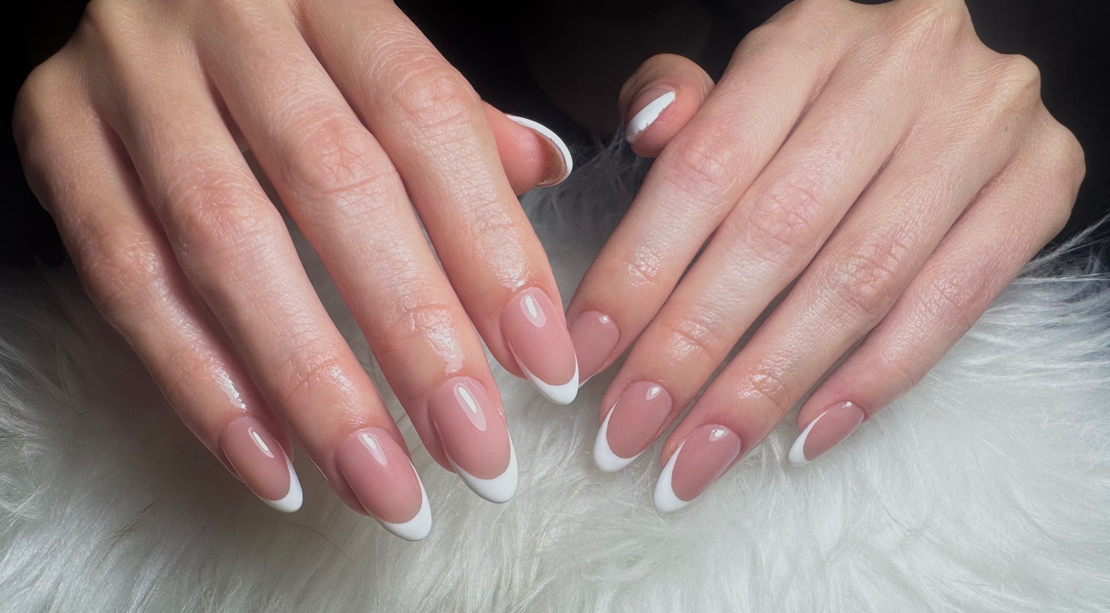 Manicura francesa elegante en Dja Nails, Heredia, Heredia, CR sobre tela blanca.