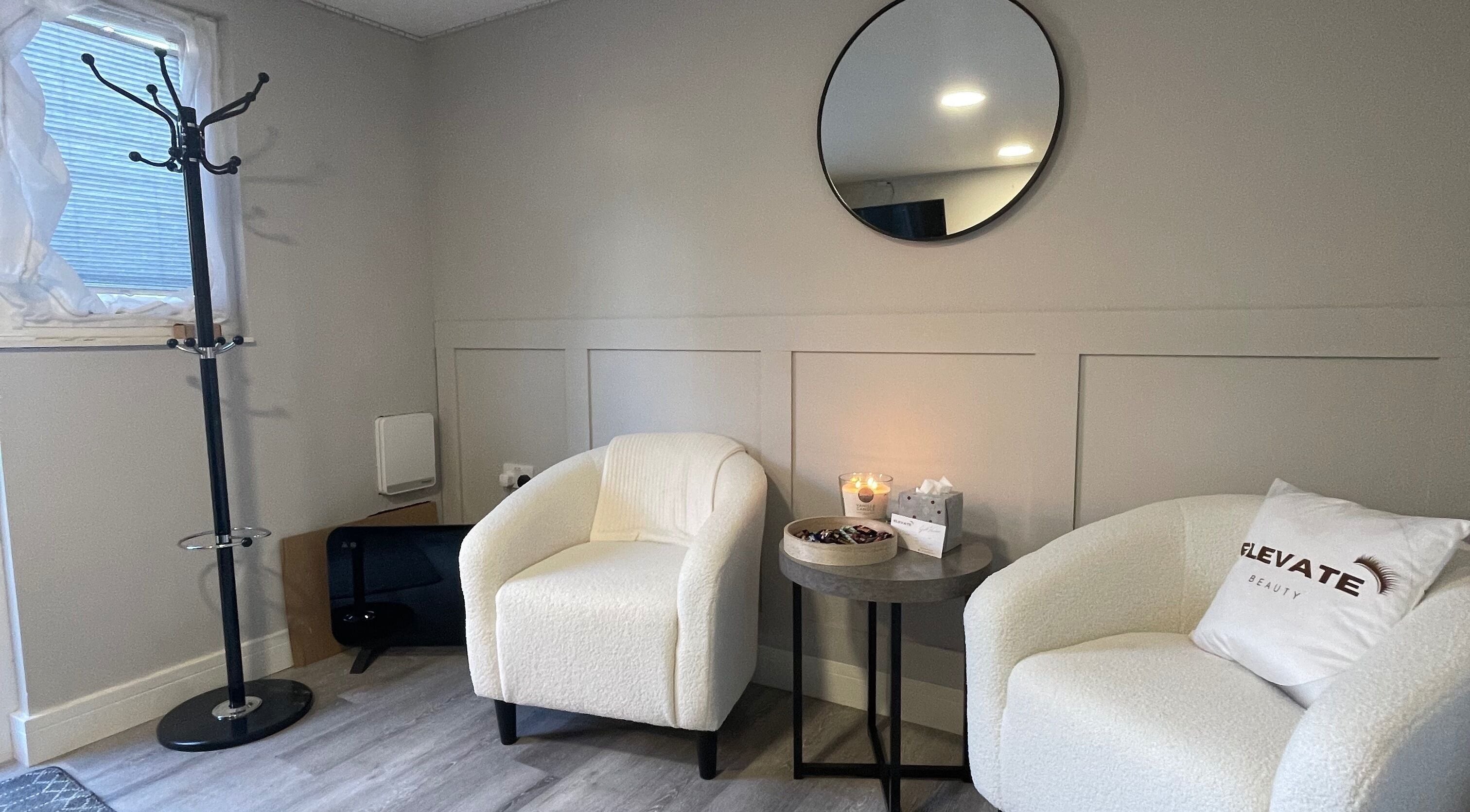 Chic lounge at Elevate Beauty in Hawkinge, England, showcasing elegant chairs and modern decor.