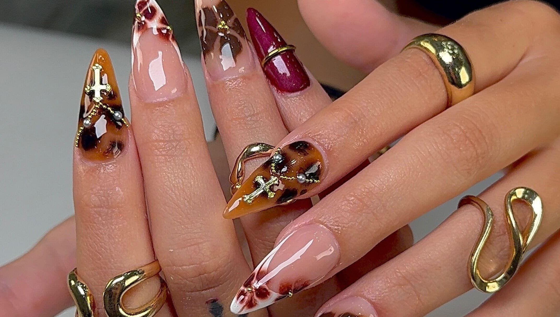 Dramatic ornamental nail design at Kayden Luong, Atlanta, Georgia, US. Featuring intricate gold patterns.