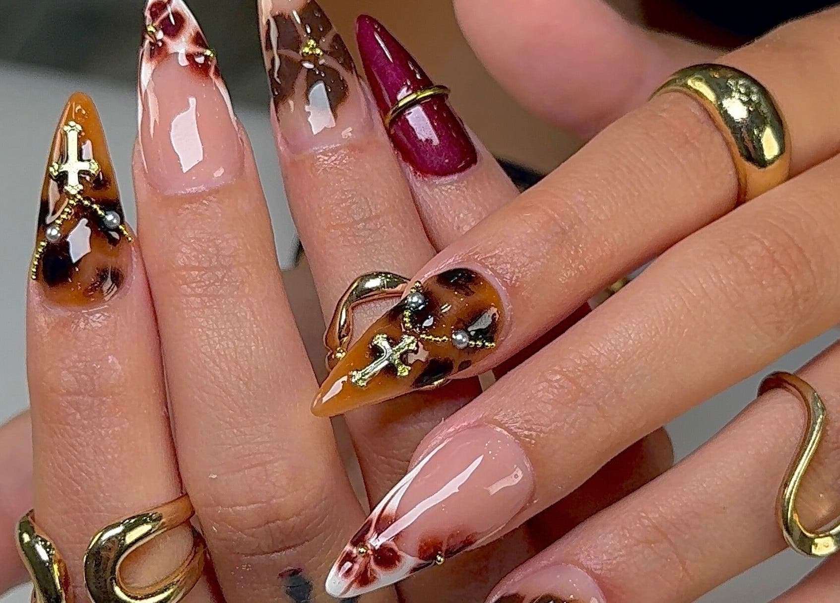 Dramatic ornamental nail design at Kayden Luong, Atlanta, Georgia, US. Featuring intricate gold patterns.
