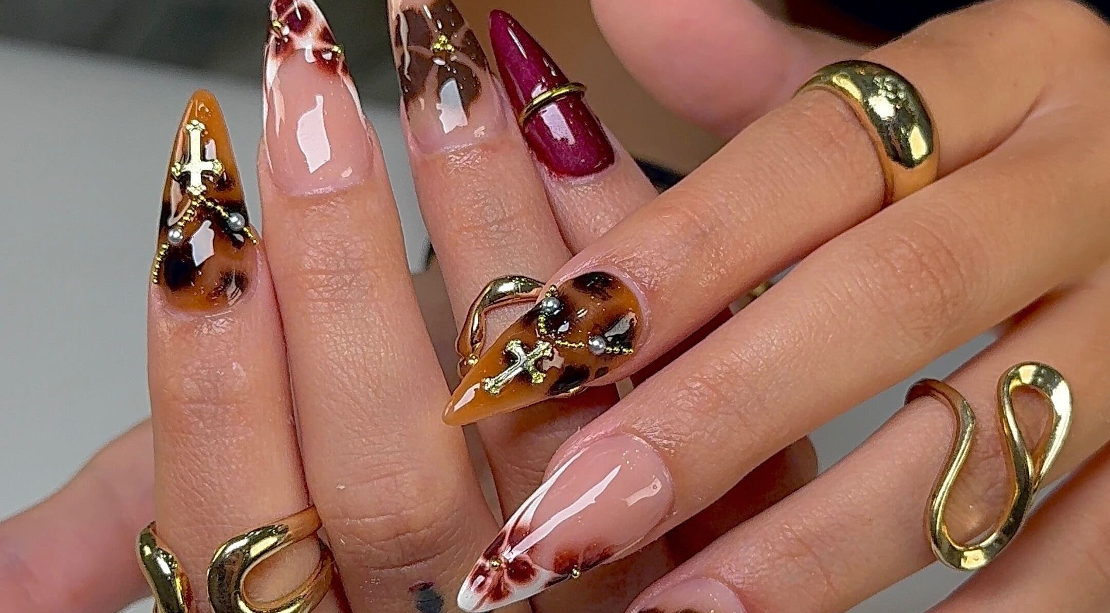 Dramatic ornamental nail design at Kayden Luong, Atlanta, Georgia, US. Featuring intricate gold patterns.