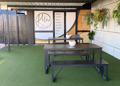 Outdoor relaxation area at Massage Relax Restore Townsville, Garbutt, Queensland, AU with benches and plants.