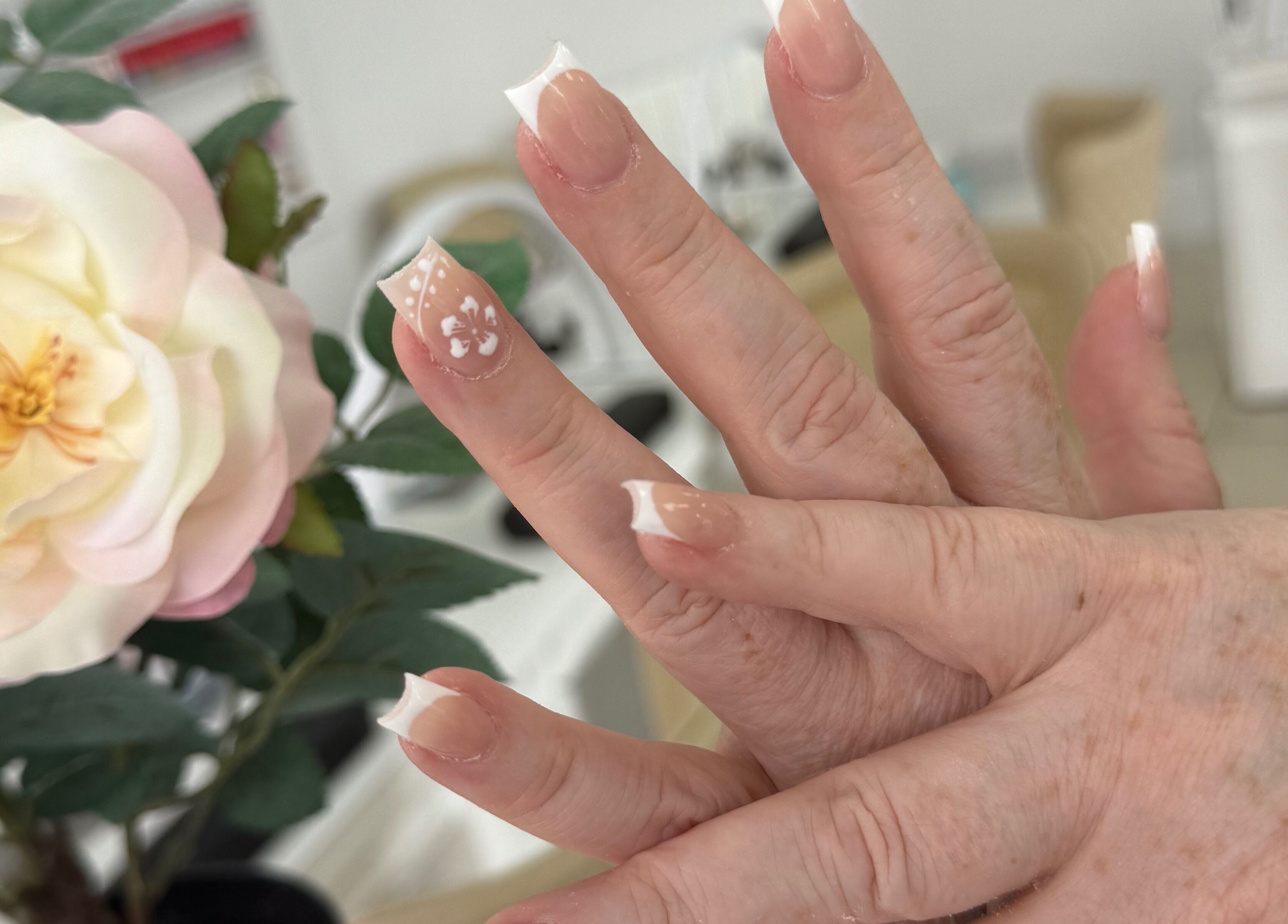 Elegant French manicure with floral design at Lux Nails & Spa Carluke, Carluke, Scotland, GB.