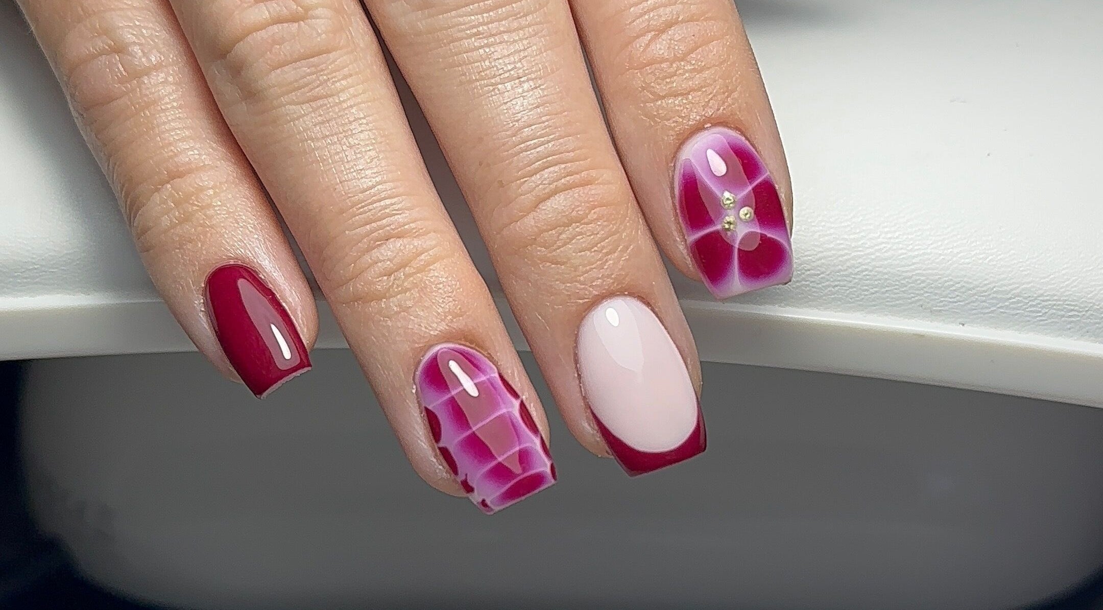 Stylish pink and red nail art at Keexbeauty, Newport, Wales, GB. Perfect blend of elegance and modern design.