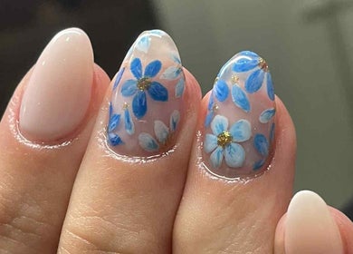 Elegant floral nail design at Leaf of Faith Beauty, Benoni, Gauteng, ZA, showcasing intricate blue flowers.