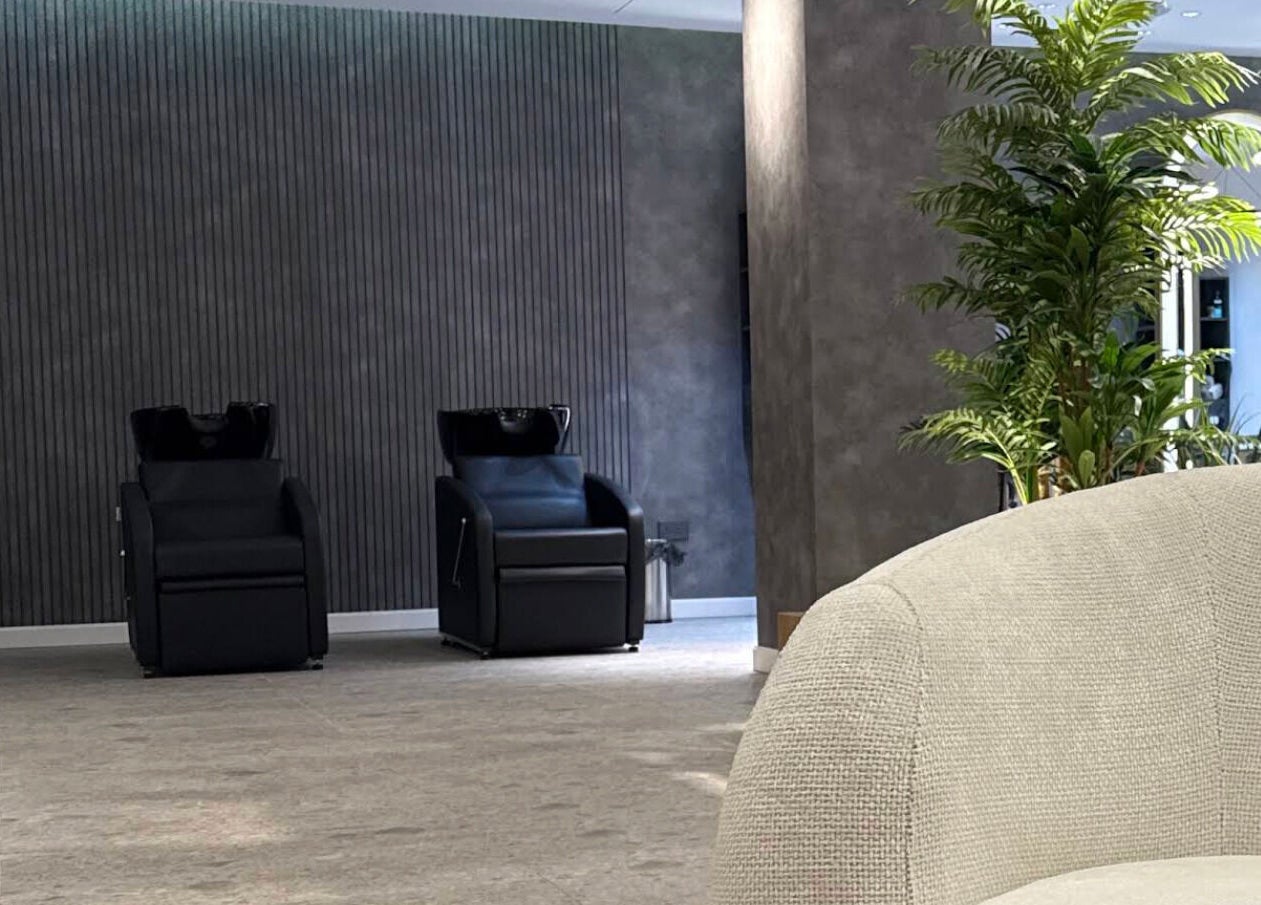 Modern lounge area in Repair Men’s Salon & Spa, featuring plush seating and greenery in الخبر, Eastern Province, SA.