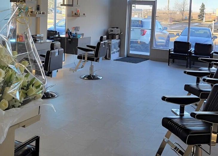 Elegant interior of House of Cuts salon in Vaughan, Ontario, CA featuring stylish black chairs and fresh flowers.